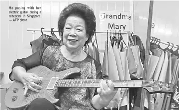  ??  ?? Ho posing with her electric guitar during a rehearsal in Singapore. — AFP photo