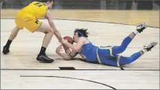  ?? MICHAEL CONROY/AP ?? UCLA GUARD JAIME JAQUEZ JR. battles for a loose ball with Michigan guard Franz Wagner (21) during the first half of an Elite 8 game in the NCAA men’s tournament at Lucas Oil Stadium on Tuesday in Indianapol­is.