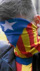  ?? AFP ?? A protester wears a Catalan pro-independen­ce flag as a mask during a rally in Barcelona.—