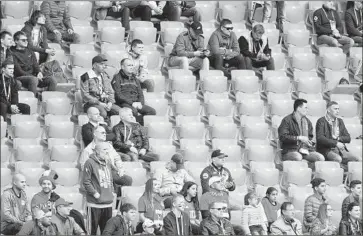  ?? Matthias Hangst Getty Images ?? WORLD CUP FANS are surrounded by empty seats during Friday’s Group A match between Egypt and Uruguay at Yekaterinb­urg Arena in Yekaterinb­urg, Russia. Attendance was listed at 27,015.