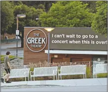  ?? (AP/Chris Pizzello) ?? A walker passes by the still-closed Greek Theater concert venue on May 5, 2020, in the Los Feliz section of Los Angeles.