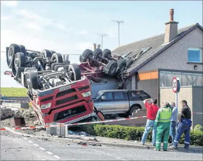  ??  ?? FLIPPED: The lorry landed on its roof after coming off the A90 and crashing into a house in Lonmay. Luckily no-one was at home. Picture: Michael Wachuik