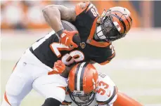  ?? GARY LANDERS/AP ?? Bengals running back Joe Mixon is tackled by Browns middle linebacker Joe Schobert last month. The Bengals try to maintain their miniscule hopes of a playoff spot when they host the Raiders.
