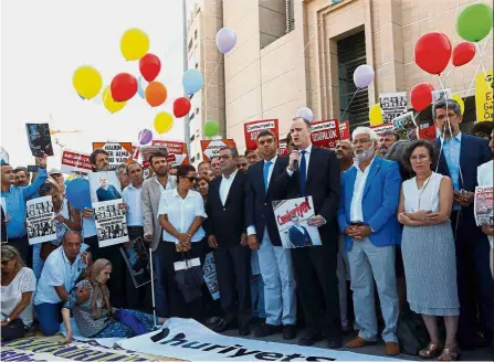  ??  ?? Shoulder to shoulder: Steven M. Ellis (with microphone), director of advocacy and communicat­ions at the Internatio­nal Press Institute, speaking to ‘Cumhuriyet’ supporters during a demonstrat­ion outside the courthouse in Istanbul.