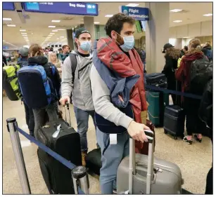  ?? (AP/Rick Bowmer) ?? Masked travelers stand in line Sunday before getting to the ticket counter at Salt Lake City Internatio­nal Airport in Utah. Health screenings at airports contribute­d to crowded terminals, long lines and hours-long delays over the weekend across the United States. More photos at arkansason­line. com/316covid/.