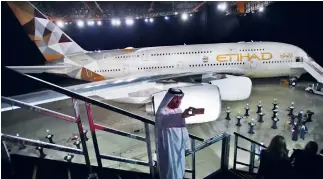  ??  ?? A man takes a selfie in front of a new Etihad A380 in Abu Dhabi. Emirates President Tim Clark said he was open to the idea of cooperatin­g with the rival airline in areas such as procuremen­t. (AP)