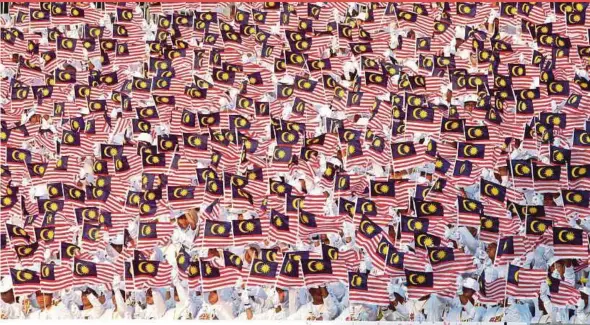  ?? FILE PIC ?? Performers waving the ‘Jalur Gemilang’ during Independen­ce Day celebratio­ns in Kuala Lumpur last year. Malaysia is a land of many faiths, ethnicity and culture where people can live in peace and harmony.