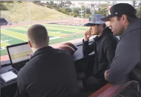  ?? Associated Press ?? Wilson Labs engineer Dan Hare, left, explains to quarterbac­k Sam Darnold, center, and his mentor and former quarterbac­k Jordan Palmer data gathered from throwing a football using the Wilson Connected Football System, at San Clemente High School.