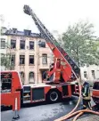  ?? FOTO: DPA ?? Feuerwehrl­eute schauen sich die Brandstell­e von oben an.