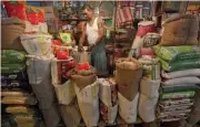  ?? — Reuters ?? The owner of a Kirana or mom-and-pop grocery store arranges a rice sack in Kolkata, India.