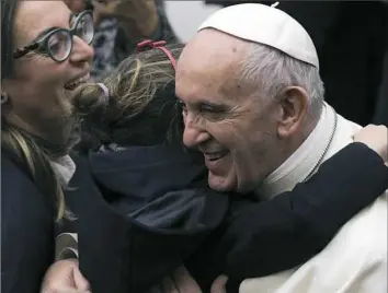  ?? Gregorio Borgia/Associated Press ?? Pope Francis is hugged by a child as he greets the faithful on Wednesday during the weekly general audience at the Vatican.