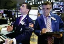  ?? RICHARD DREW — THE ASSOCIATED PRESS FILE ?? Trader Peter Mazza, left, works with trader Daniel Trimble on the floor of the New York Stock Exchange.