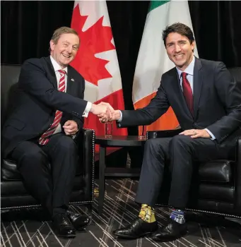  ??  ?? Taoiseach Enda kenny greets Canadian Prime Minister Justin Trudeau in Montreal. Inset: a close-up of Mr Trudeau’s R2D2 Star Wars-themed socks. Photos: Paul Chiasson