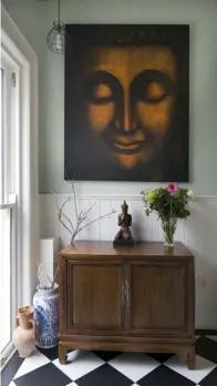  ??  ?? RIGHT: A detail of the hall with its black and white tiling. Both the painting and the buddha are just some of the items Kate and Mike brought back from their home abroad