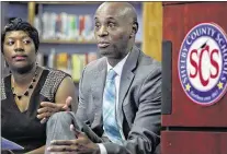  ?? JIM WEBER/THE COMMERCIAL APPEAL ?? Riverview Middle School Principal Rosalind Martin (left) listens as Shelby County Schools Superinten­dent Dorsey Hopson announces the district is suing the state, claiming underfundi­ng disproport­ionately hurts poor children.