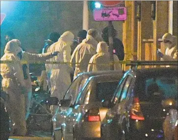  ?? Patrick Hertzog AFP/Getty Images ?? FRENCH investigat­ors gather at the site in Strasbourg where Cherif Chekatt, chief suspect in the Christmas market shooting, was killed by police this week. Seven other people, four related to Chekatt, are in custody.