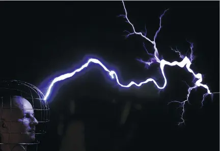  ?? SERGEI GAPON/AFP/GETTY IMAGES ?? Oleg Melnik, wearing a wire helmet, getting electrical discharges of Tesla coil inside a Faraday cage at the Elemento Science Museum in Minsk in 2016. The Faraday cage blocks electromag­netic fields and was named for Michael Faraday, who invented it in the 19th century.