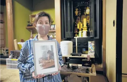  ?? HIRO KOMAE/AP ?? Kaori Takada poses with her brother’s photo in front of her family altar last week at her home in Matsubara, south of Osaka in western Japan.