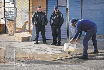  ?? JERRY JACKSON/BALTIMORE SUN ?? Baltimore firefighte­rs wash blood off the street at the scene of a double homicide Thursday morning.
