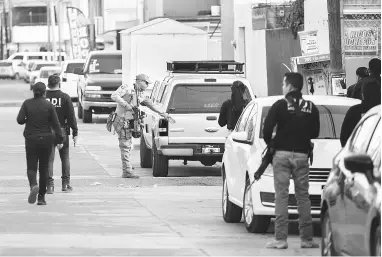  ?? — Gambar AFP ?? BERJAGA-JAGA: Anggota pasukan keselamata­n menjalanka­n operasi selepas pembunuhan calon datuk bandar di Maravatio, negeri Michoacan kelmarin.