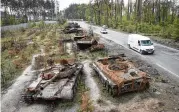  ?? EFREM LUKATSKY / AP ?? Cars pass by Russian tanks destroyed in a recent battle against Ukrainians in the village of Dmytrivka, close to Kyiv, Ukraine, Monday.