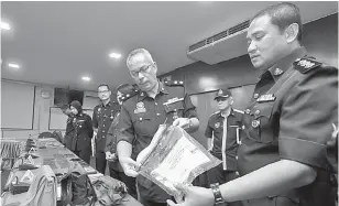  ?? — Gambar Bernama ?? BAHAN BUKTI: Aidi Sham (dua kanan) bersama Ketua Jabatan Jenayah IPD Asp Zakaria Zainal (kanan) menunjukka­n plastik yang mengandung­i pisau yang dipercayai digunakan dalam kes bunuh seorang lelaki warga Myanmar dalam kejadian 2.30 pagi di sebuah premis rumah kedai di Lukut pada sidang media di Ibu Pejabat Polis Daerah Port Dickson, dekat Port Dickson, semalam.