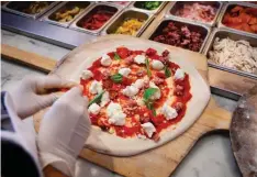  ??  ?? Customise your pizza with the wide variety of toppings available including beef pepperoni, salami, Philly beefsteak, and prawns