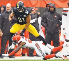  ?? Ron Schwane / Associated Press ?? Cleveland Browns defensive back Damarious Randall (23) tackles Pittsburgh Steelers tight end Jesse James during the first half of a game in Cleveland. In a slopfest of an opener, the Steelers and Browns tied 21-21.