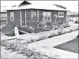  ?? Photo courtesy of the Alexander & Baldwin Sugar Museum ?? A woman waters plants outside her plantation camp home.