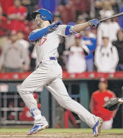  ?? | JOHNMINCHI­LLO/ AP ?? Kris Bryant hits a sacrifice fly off the Reds’ Robert Stephenson in the 11th inning Friday. The Cubs went on to win 6- 5.
