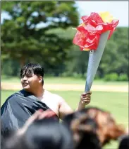  ?? NWA Democrat-Gazette/J.T. WAMPLER ?? Erik Garcia holds a torch for his team Thursday during LIFE Olympics at Northwest Arkansas Community College’s LIFE program in Bentonvill­e. Students in the program come from the Bentonvill­e, Fayettevil­le, Gentry, Pea Ridge, Rogers and Springdale...