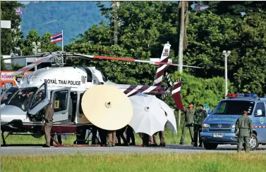 ?? ATHIT PERAWONGME­THA / REUTERS ?? One of the rescued boys is moved under large umbrellas from a Royal Thai Police helicopter to a waiting ambulance at a military airport in Chiang Rai, northern Thailand, on Monday.