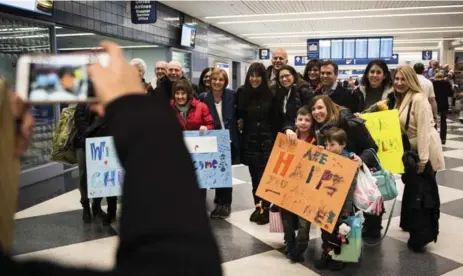  ?? HILARY SWIFT/THE NEW YORK TIMES ?? Volunteers from Am Shalom, a synagogue in Glencoe, Illinois, wait to greet a Syrian refugee family at Chicago’s O’Hare Internatio­nal Airport on Friday.