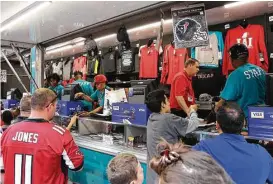  ?? Yi-Chin Lee / Houston Chronicle ?? Fans wait Sunday to buy Super Bowl LI souvenirs at Discovery Green. Records were set at the Super Bowl for concession spending.