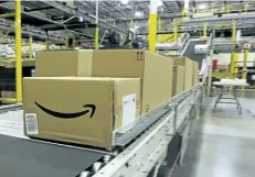  ?? THE ASSOCIATED PRESS FILES ?? Above: A box from Amazon moves along a conveyor belt at Amazon’s fulfilment centre in DuPont, Wash. Even though Canada’s biggest online retailers are growing faster than their American counterpar­ts, close to half of Canadians’ online purchases are made...