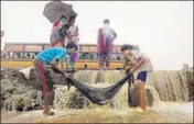  ?? AP, REUTERS & PTI ?? (Clockwise from top) People wade through a waterlogge­d area in Chennai on Friday; a woman makes her way through an inundated road; and locals try to catch fish after a compound wall collapsed in neighbouri­ng Redhills.