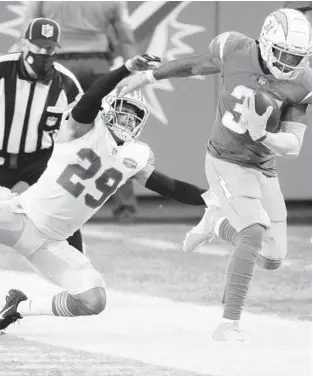  ?? DOUG MURRAY/AP ?? Chargers running back Kalen Ballage, right, is pushed out of bounds by Dolphins safety Brandon Jones on Nov. 15 in Miami Gardens.