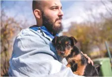  ?? Of ?? A worker holds a puppy at the Prishtina Dog Shelter near the town Gracanica.