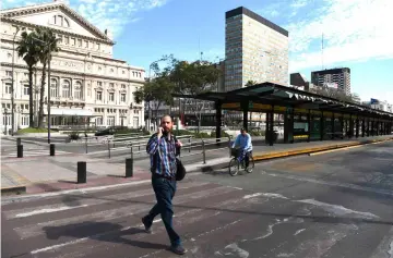  ??  ?? A man crosses the empty 9 de Julio avenue in Buenos Aires, during a 24 hours general strike on September 25. With no public transport or taxis running, Tuesday’s strike was largely respected, as many shops remained closed and citizens found themselves unable to get to work. — AFP photo