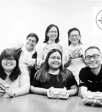  ??  ?? Maria (front row, centre), Gan (back row, right) and organising committee members display tickets to the annual dinner of Ex-Highians’ Associatio­n Kuching.