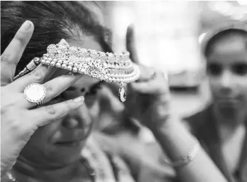  ??  ?? A customer tries on a gold necklace at the Umedmal Tilokchand Zaveri jewellery store during the festival of Dhanteras, two days before Diwali, in Mumbai on Nov 9, 2015. — WP-Bloomberg photo