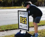  ?? MARSHALL GORBY/STAFF ?? Jackie Porter manager of Bee-gee’s Market on Bigger Road in Kettering updates the amount of the jackpot Friday for the Powerball drawing.