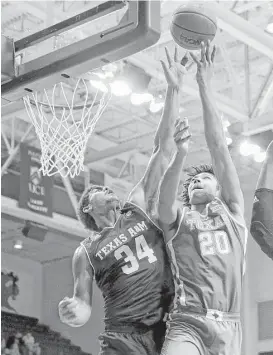  ?? Tim Warner ?? A&M’s Tyler Davis, left, tries to block the shot of Texas’ Jericho Sims.