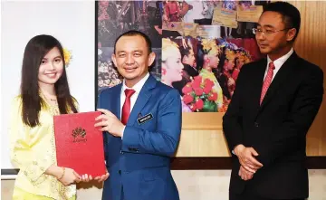  ??  ?? Maszlee (centre) presents an award to a participan­t, Lim Yii Vonne from Universiti Malaysia Sarawak. — Bernama photo