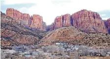  ?? RICK BOWMER/ASSOCIATED PRESS ?? Hidlale, Utah, is at the base of the Red Rock Cliff mountains, with its sister city, Colorado City, Ariz., in the foreground. Both are involved in a court hearing into discrimina­tion by the shared police department.