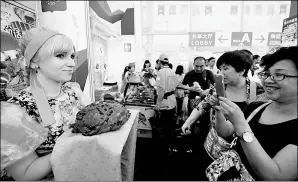  ?? XINHUA ?? A visitor to a trade fair in Harbin, capital of Heilongjia­ng province, photograph­s a woman in traditiona­l Russian costume.