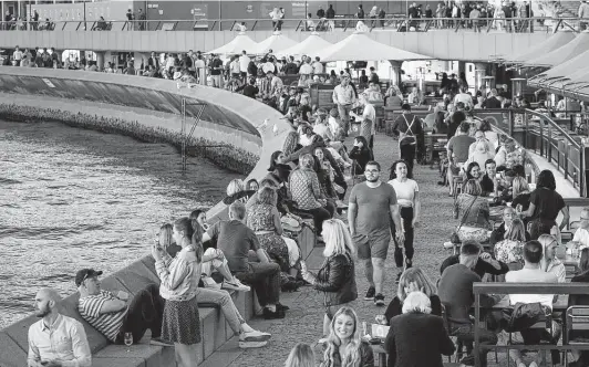  ?? Lisa Maree Williams / Bloomberg ?? Crowds fill bars and restaurant­s April 30 at Circular Quay in Sydney. China, Singapore, Australia and New Zealand have had fewer COVID deaths than many countries.