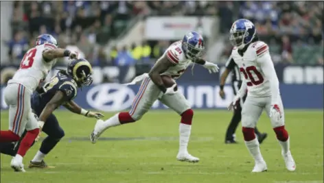  ?? THE ASSOCIATED PRESS ?? Giants safety Landon Collins (21), center, runs through before scoring a touchdown against the Los Angeles Rams at Twickenham stadium in London on Sunday.