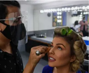  ?? AFP ?? Todos los estilistas debían utilizar mascarilla y careta para maquillar a las concursant­e del Miss Venezuela.