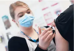  ?? ALASTAIR GRANT/AP ?? Pharmacy technician Katrina Bonwick administer­s the AstraZenec­a vaccine Thursday in Luton, England. The European Medicines Agency said the vaccine is safe.